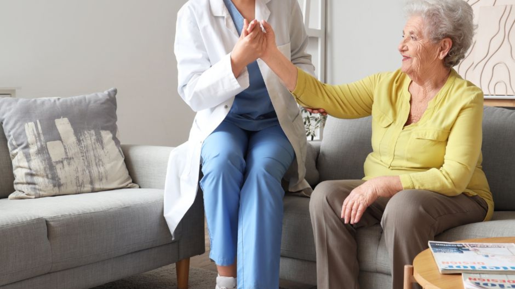 Caregiver providing compassionate in-home support to an elderly woman in a living room setting in Maryland