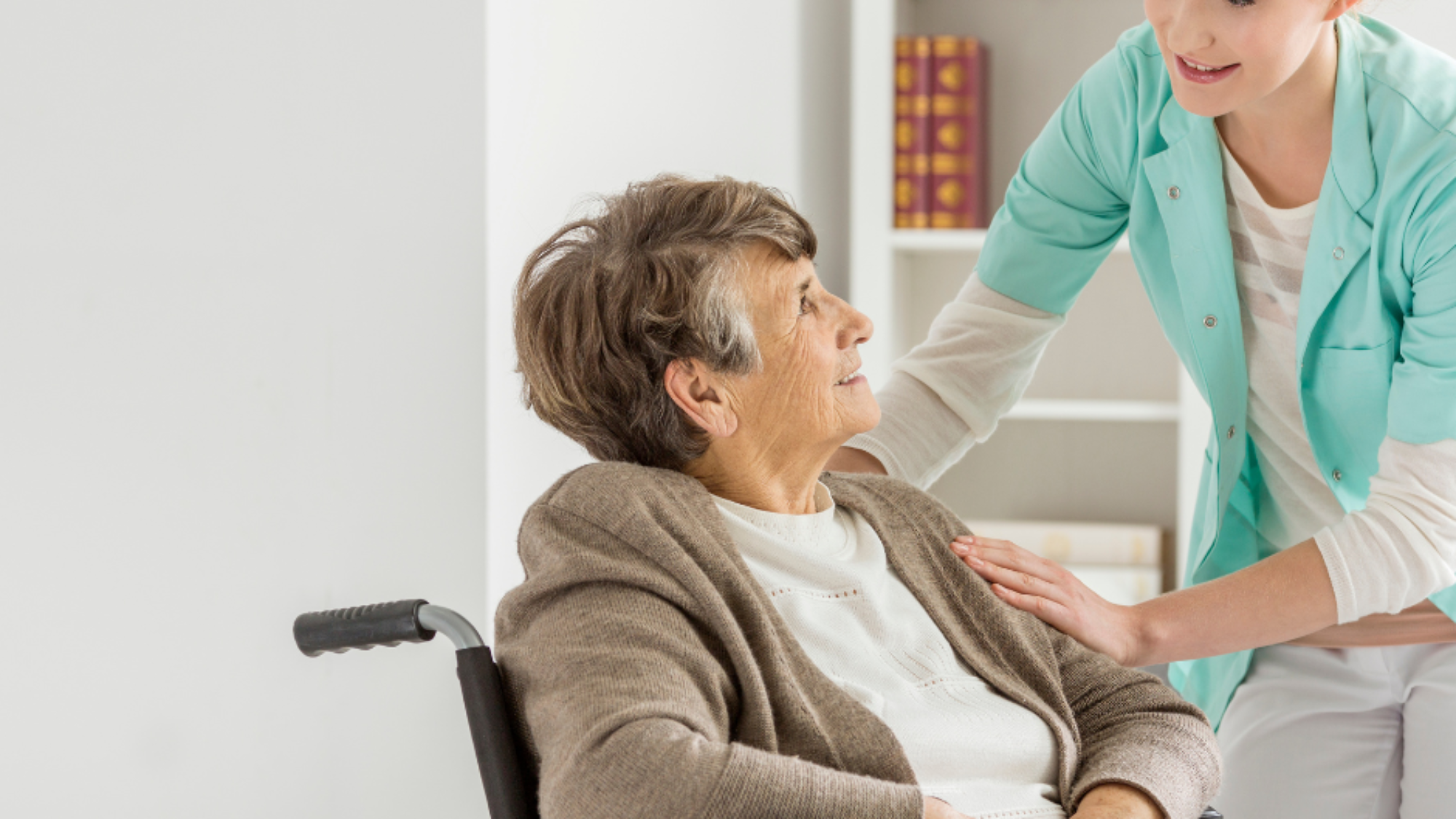 Licensed nurse providing skilled nursing Fort Washington care to an elderly woman in a wheelchair inside her home.